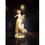 A Lladro figurine of a girl feeding her goose,