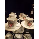 Six Royal Worcester coffee cans and saucers with faux bamboo handles and decorated with floral