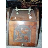 A wooden coal bucket with brass fittings and floral design