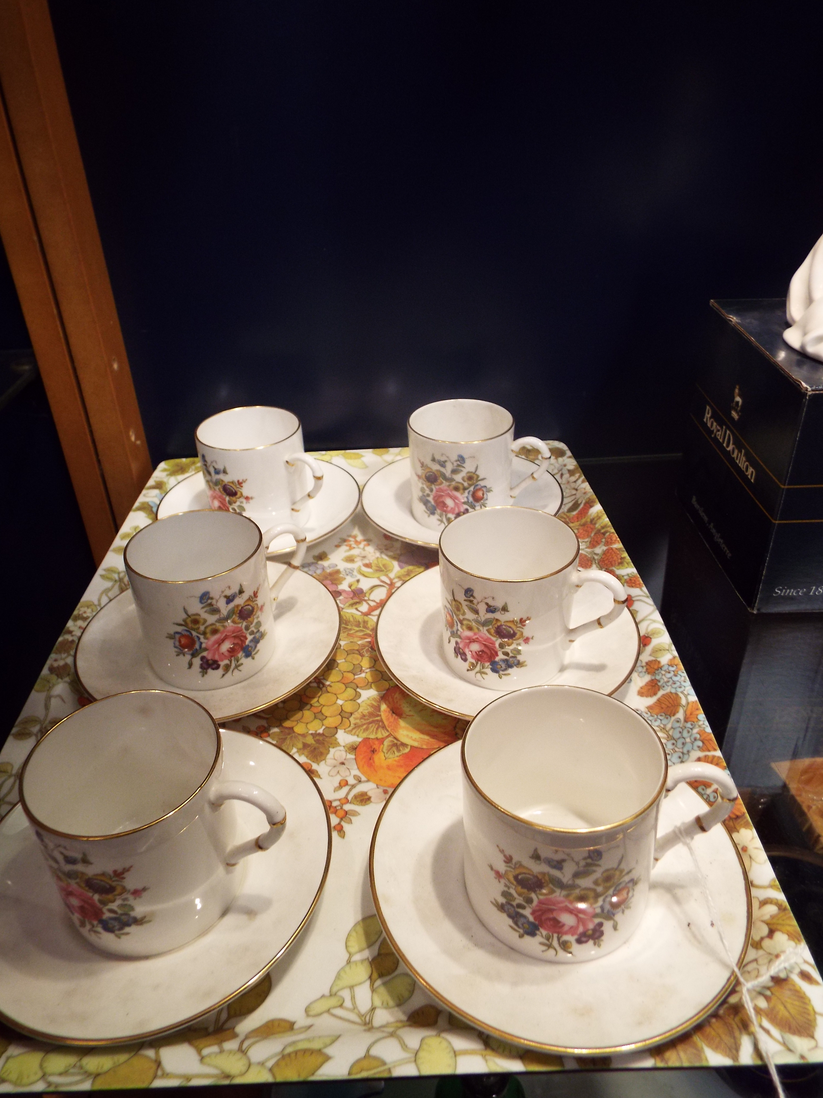 Six Royal Worcester coffee cans and saucers with faux bamboo handles and decorated with floral