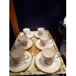 Six Royal Worcester coffee cans and saucers with faux bamboo handles and decorated with floral