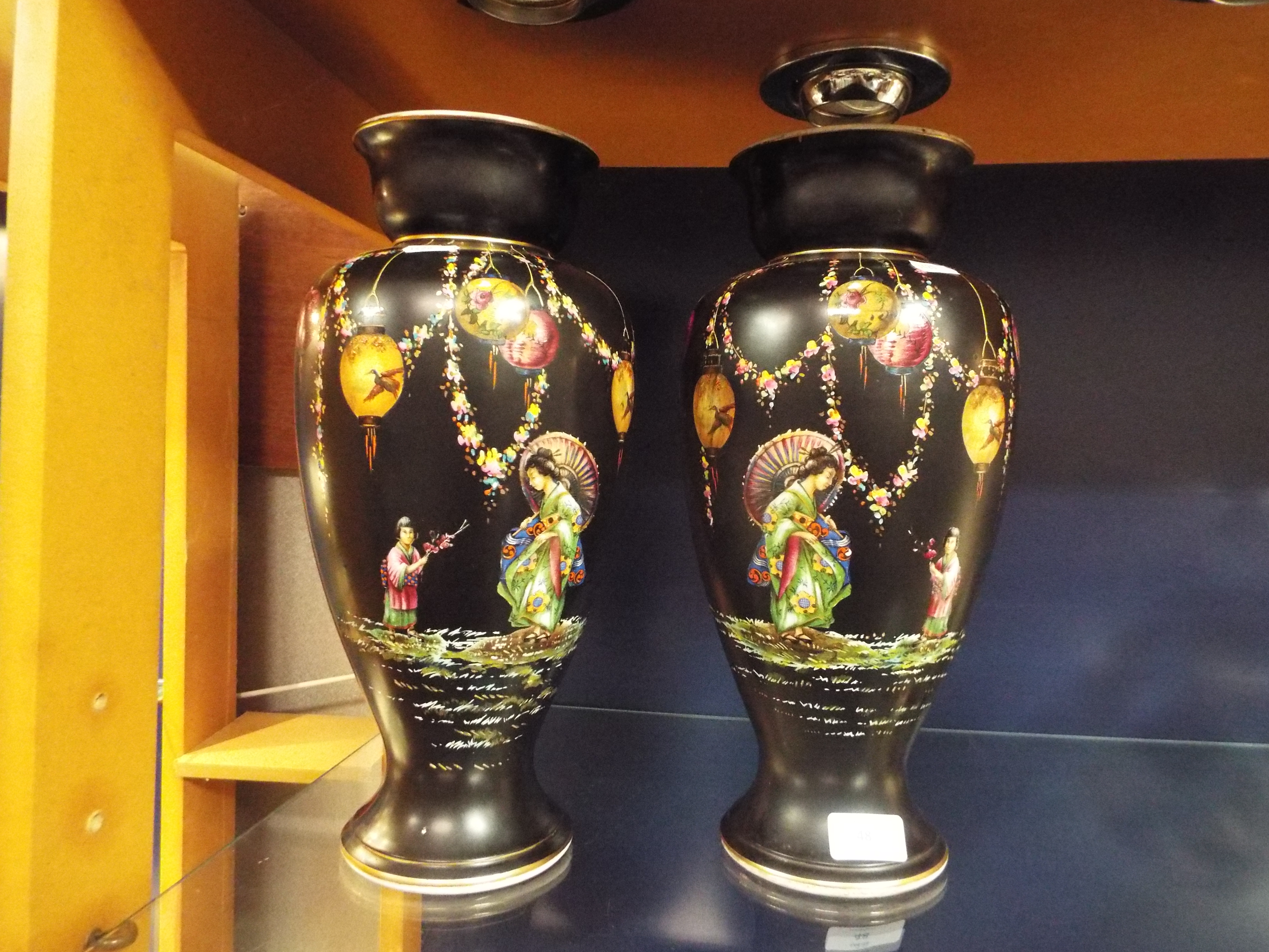 A pair of Japanese black ground vases having pictorial pattern depicting Geisha girl and floral