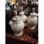 Three white ground crackle glazed lamps having floral pattern