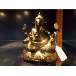 A patinated and gilt figure of Ganesha