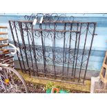 A pair of black painted wrought iron driveway gates