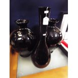 A pair of black vases of ovoid form together with a similar bottle vase