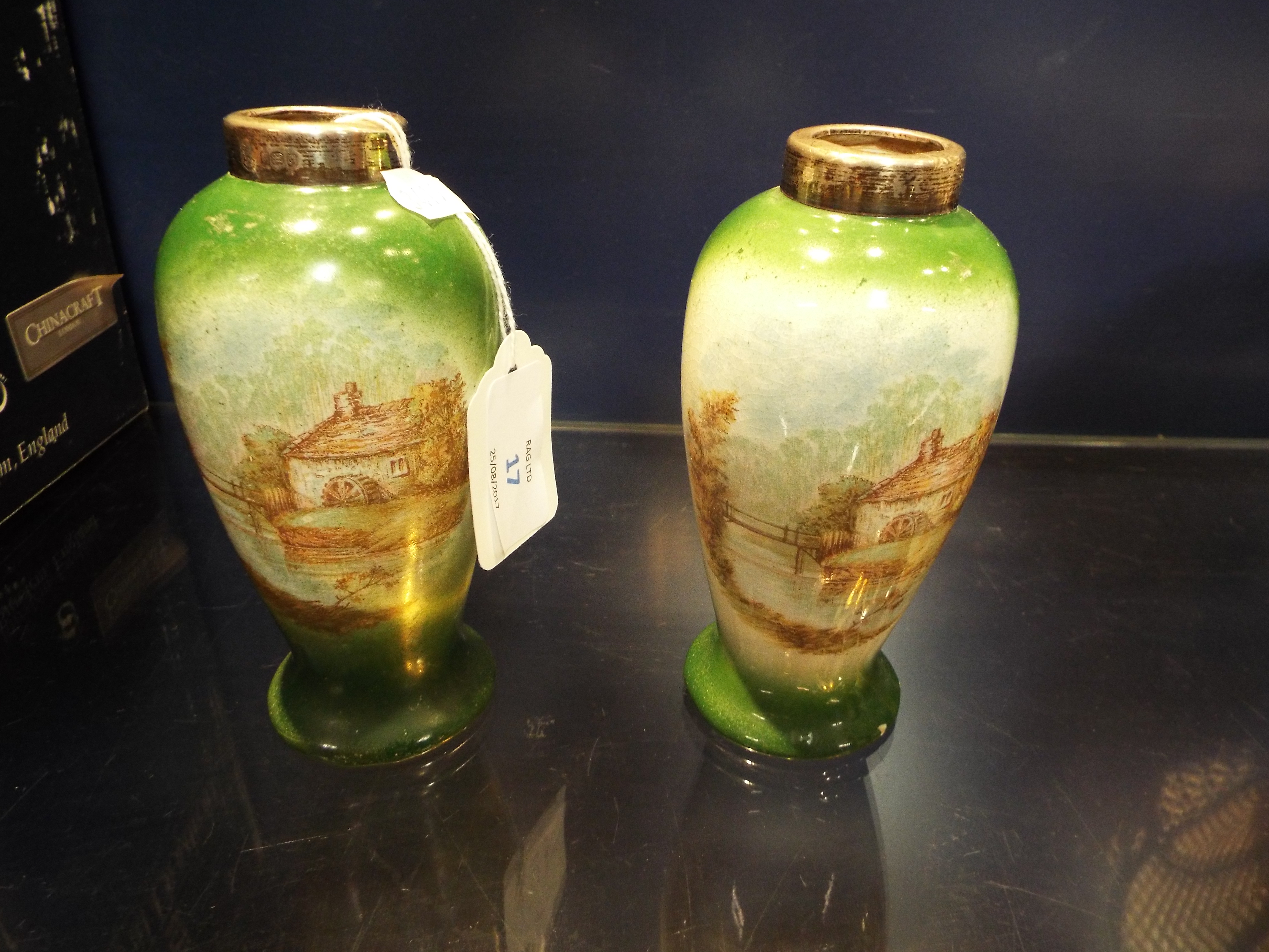 A pair of transfer printed vases of ovoid form each with silver collars