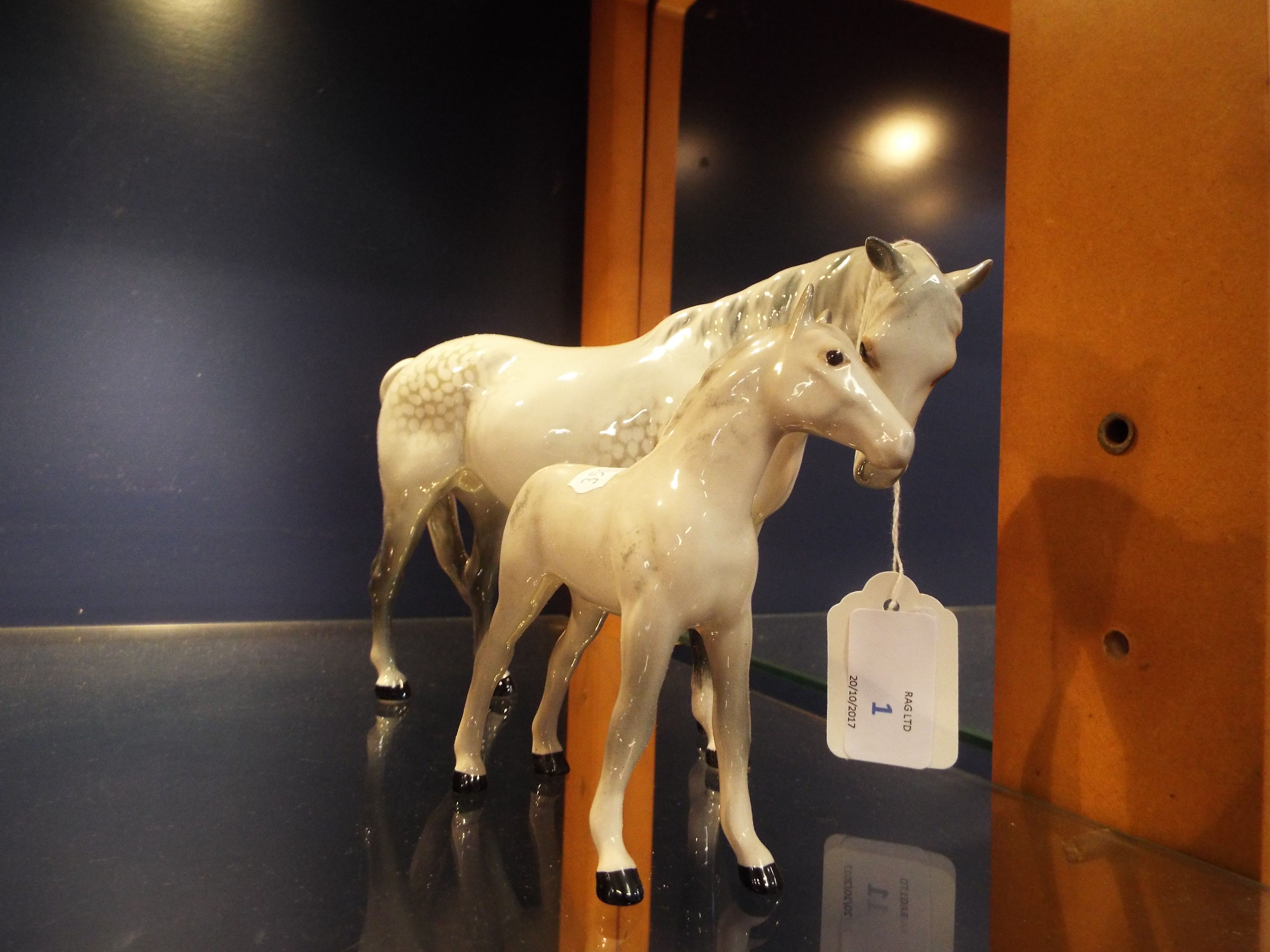 A Beswick dapple grey horse facing right and a dapple grey foal