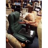 A green upholstered faux leather reclining armchair with matching footstool