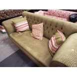 A green upholstered Chesterfield