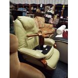 A light green leather Stressless armchair with foot stool