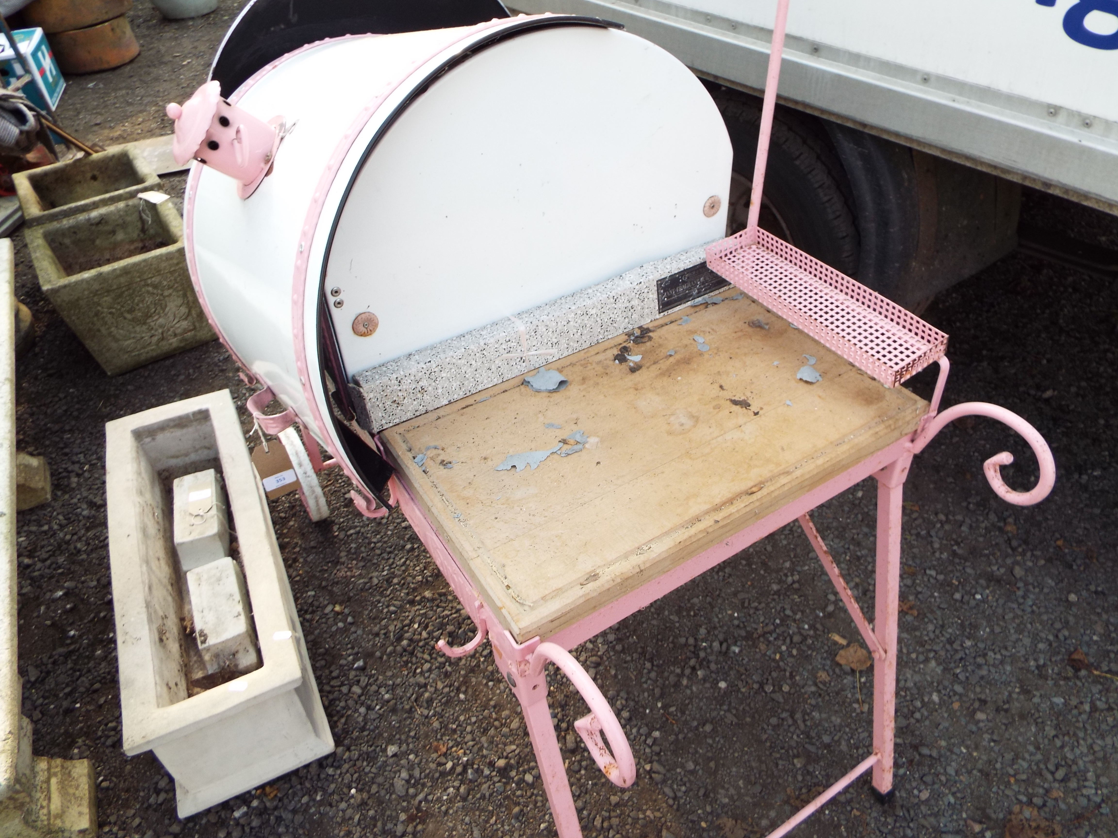 A portable pink and white enamel drum BBQ