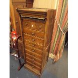 An oak tambour shutter chest of two short and eight long drawers