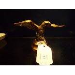 A brass car mascot of an eagle