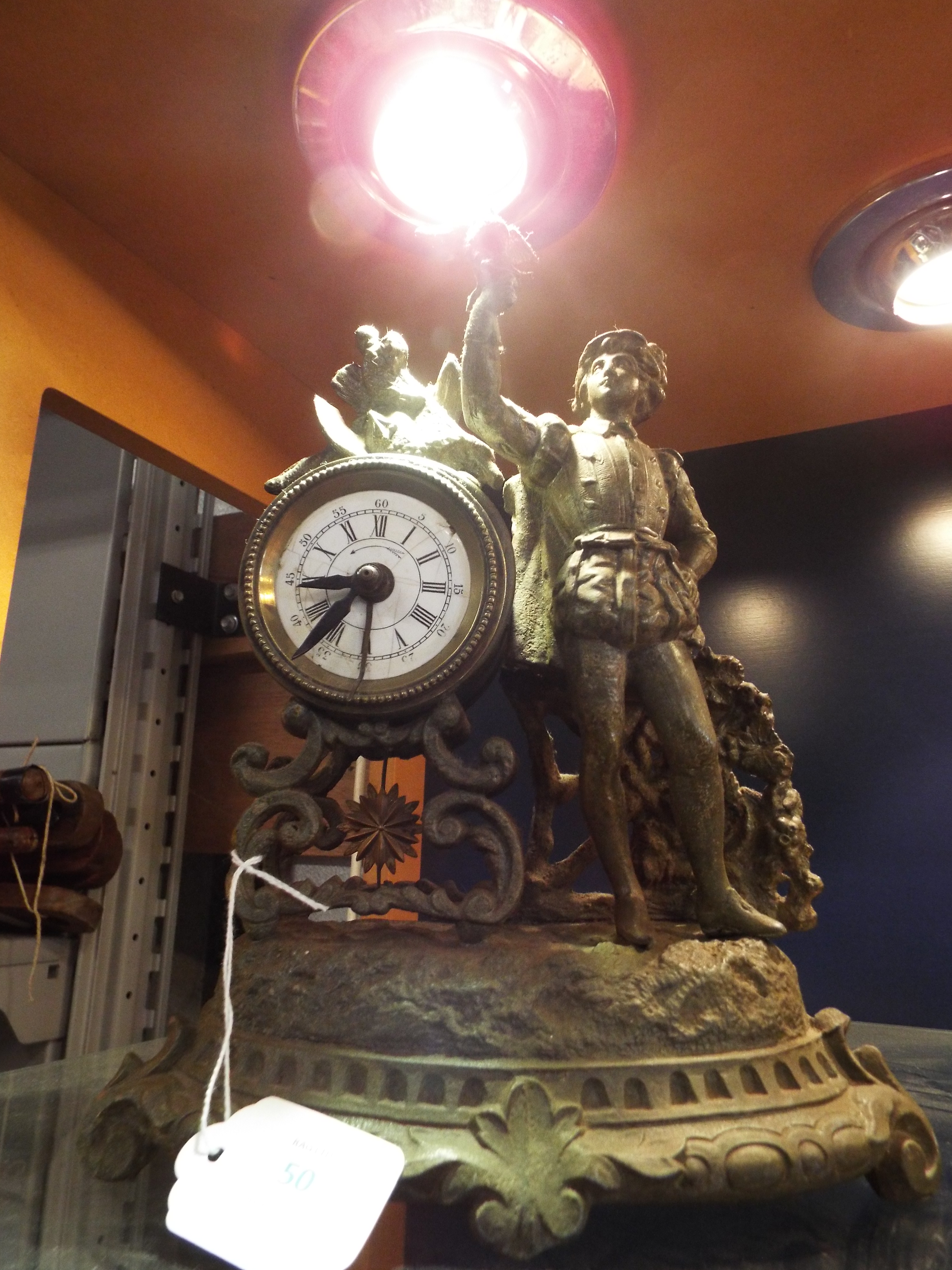 A French spelter mantel clock in the form of a young boy with bird,