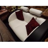 A retro style faux black and white leather two seater sofa with head rests