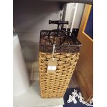 A wicker and wrought iron umbrella stand together with a wrought iron wine bottle holder