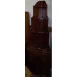 Mahogany corner unit with three open shelves above lower cupboard