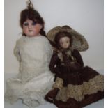 Bisque head doll with blinking eyes and leather body and small bisque head doll
