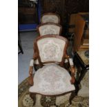 Pair of French style walnut effect framed armchairs with needlework upholstered seat,