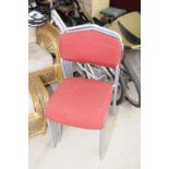 Set of four stacking chairs with upholstered seats and backs and metal frames