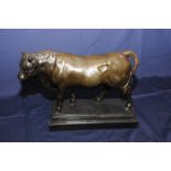 Large modern bronze figure of a bull on stepped marble base