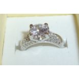 Silver ring set with large central raised cz stone and flanked by cz chipped shoulders stamped 925