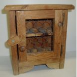 Small pine egg house with wire mesh door and internal shelves for holding eggs