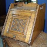 Early 20th C golden oak slope front coal box with carved panel door