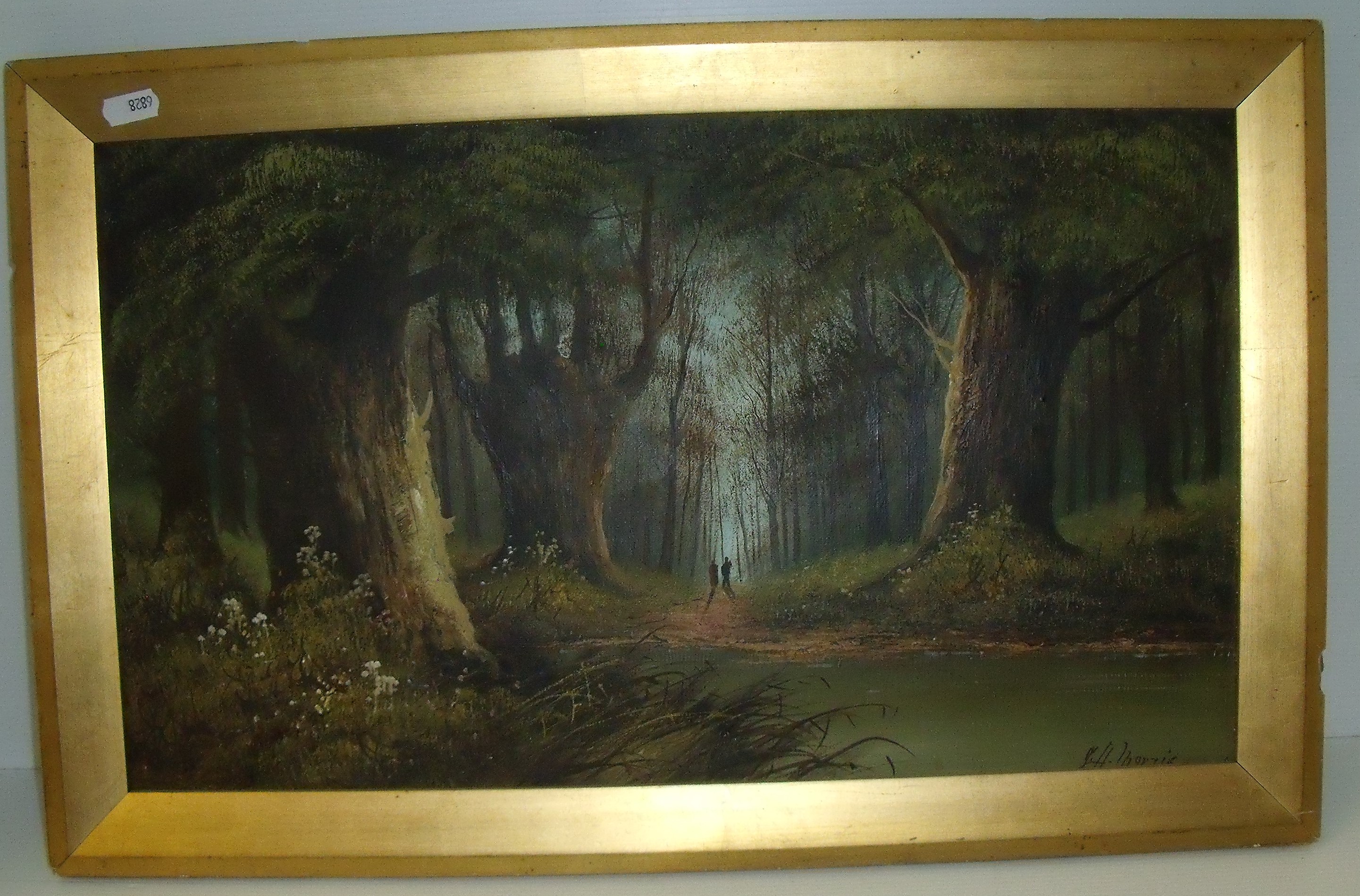 Gilt framed oil on canvas depicting wooded landscape with river to foreground signed G Harris