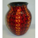 Poole Pottery vase in red glaze with squiggle patterns covering the body