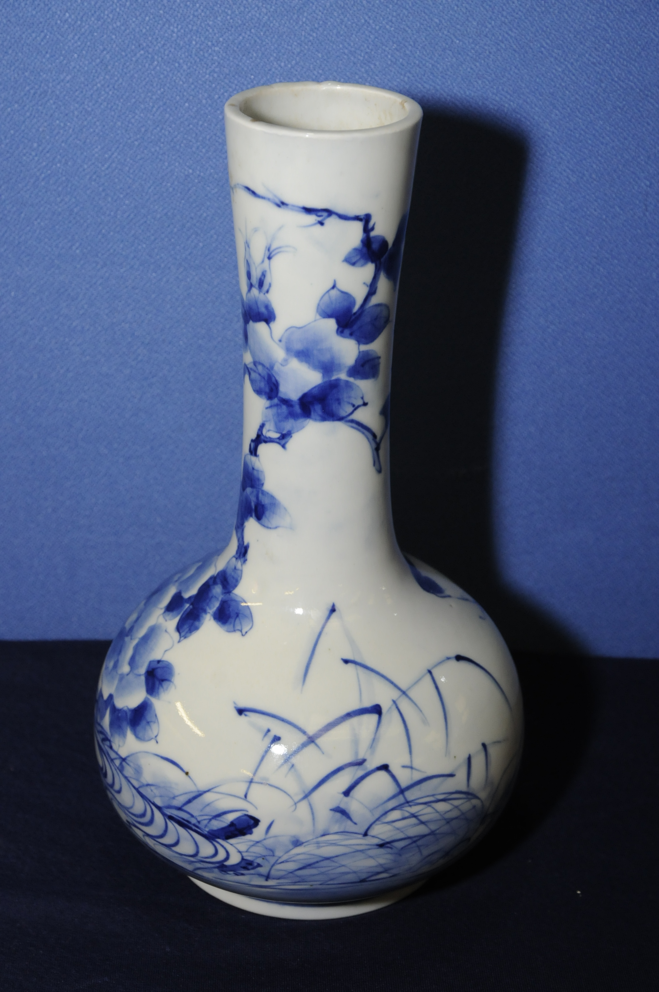Japanese blue and white bottle neck vase depicting various foliage with nine digit signature panel