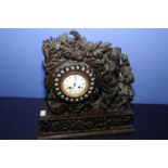 Unusual Victorian heavily oak carved cased mantel clock the dial surrounded by oval and plural