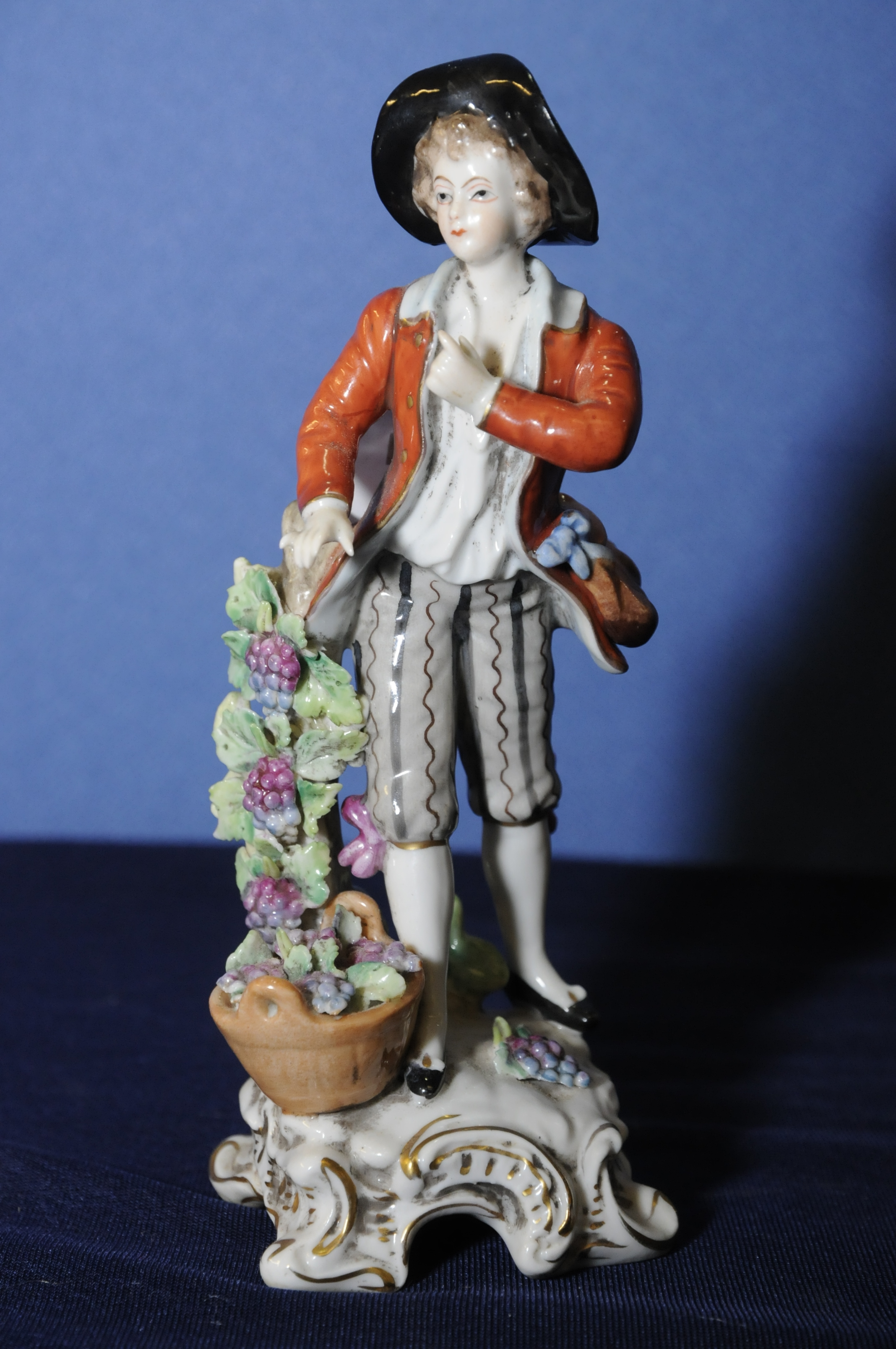 19th C Dresden porcelain figurine of a grape seller with blue printed mark to base (7cm high)