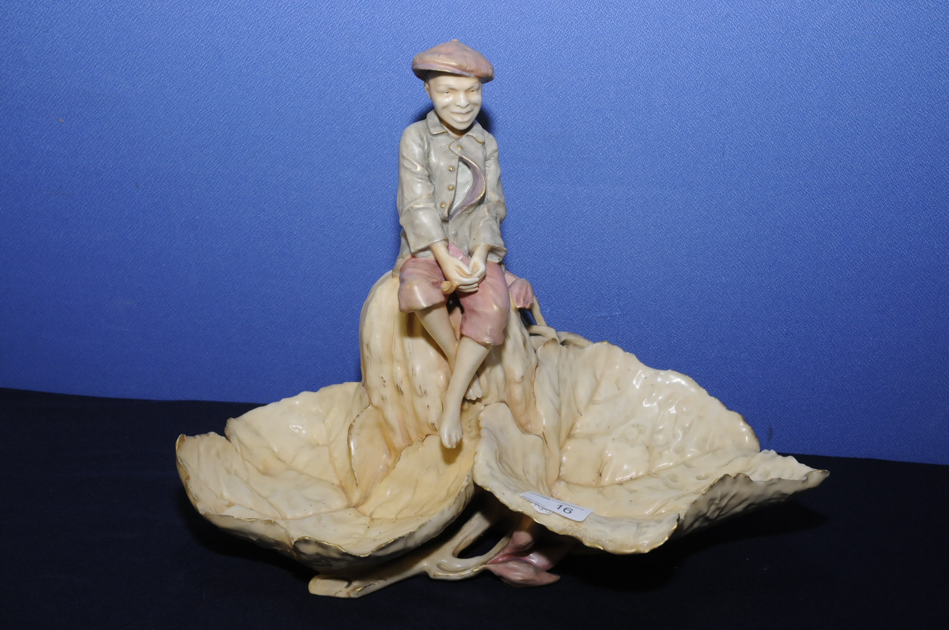 Amphora porcelain centre piece of a young boy mounted upon a rock with two large leaf petals,