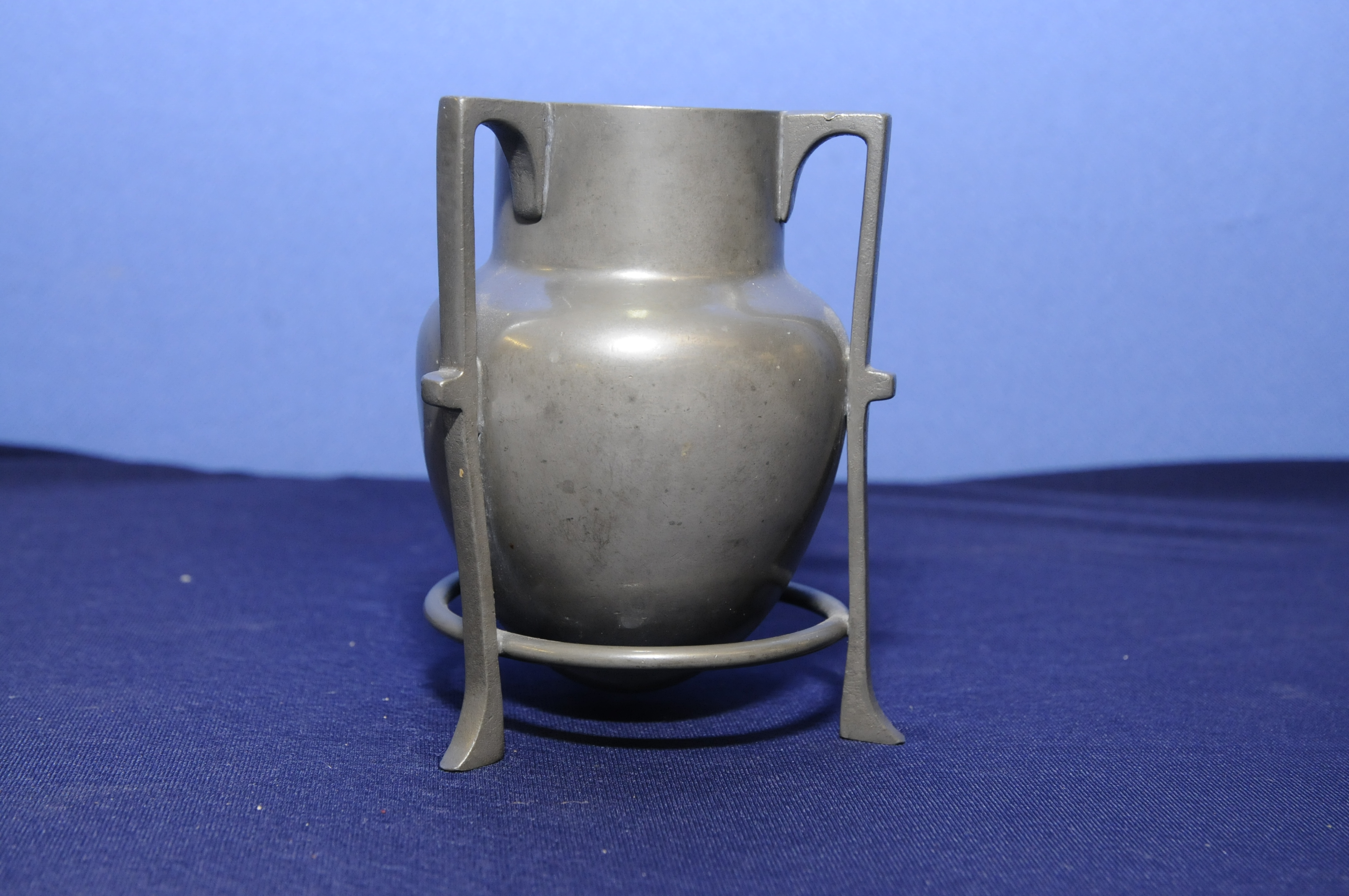 Pewter Arts & Crafts vase on three raised supports,