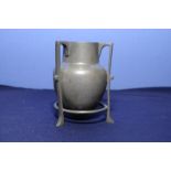 Pewter Arts & Crafts vase on three raised supports,