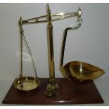 Set of brass scales and weights on mahogany plinth