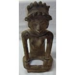 Unusual South American pottery figure of a seated woman wearing headdress,