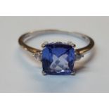 18ct white gold ring set with square central tanzanite flanked by two small diamonds (size P)