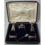 Cased silver plated condiment set comprising two salts with blue glass liners,