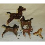 Two Beswick foals and three similar horses,