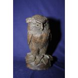 Black Forest carved wood figure of a owl with inset glass eyes on circular base (27cm high)