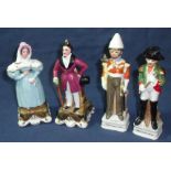 A pair of Staffordshire style figurines depicting a man in crimson frock coat and top hat and a