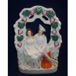 Staffordshire flat back figure group of a courting couple with arched top painted with bunches of