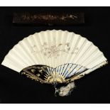 A late 19th / early 20th century gilt decorated black lacquer & embroidered silk fan, in fitted