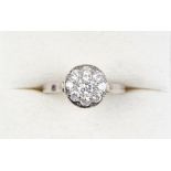 A French platinum diamond cluster ring, the central brilliant cut stone approximately 0.2 carat, the