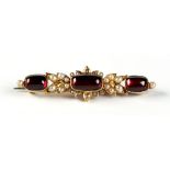 A Victorian oval cabochon garnet seed pearl & diamond brooch, 1.9ins. (4.8cms.) long (excluding pin)