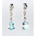 A pair of aquamarine & diamond pendant earrings, each with three round brilliant cut diamonds