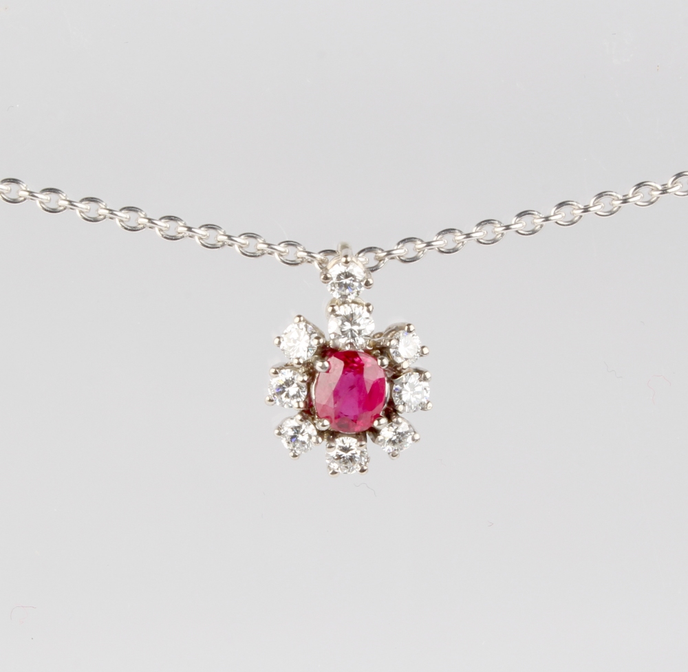 A white gold ruby & diamond cluster pendant, with central cut ruby set within a border of eight